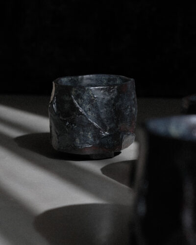 Hand-crafted Ondou Kurinuki Cup Nº1 made from black stoneware in a dramatic contrasted light.