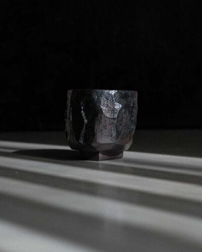 Hand-crafted Ondou Kurinuki Cup Nº1 made from black stoneware in a dramatic contrasted light.