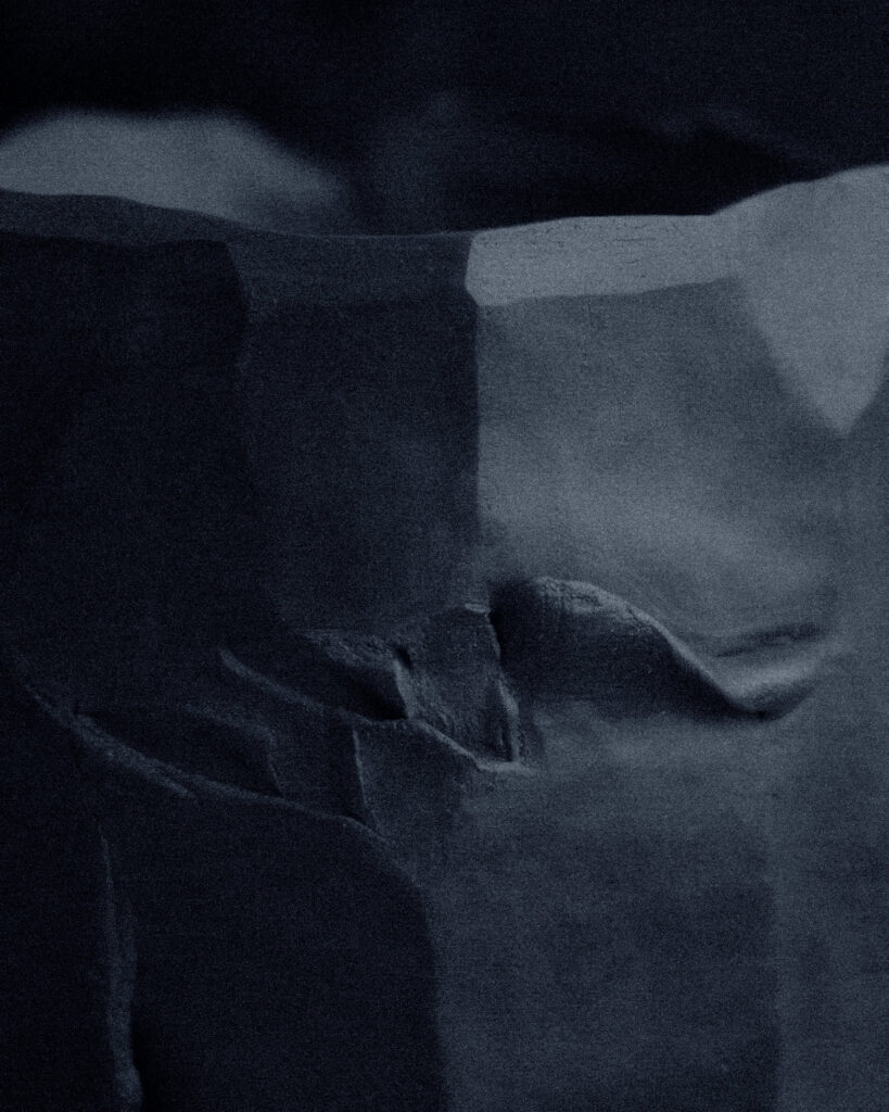 Macro detail of carved stoneware surface — organic marks and concave planes of a kurinuki vessel