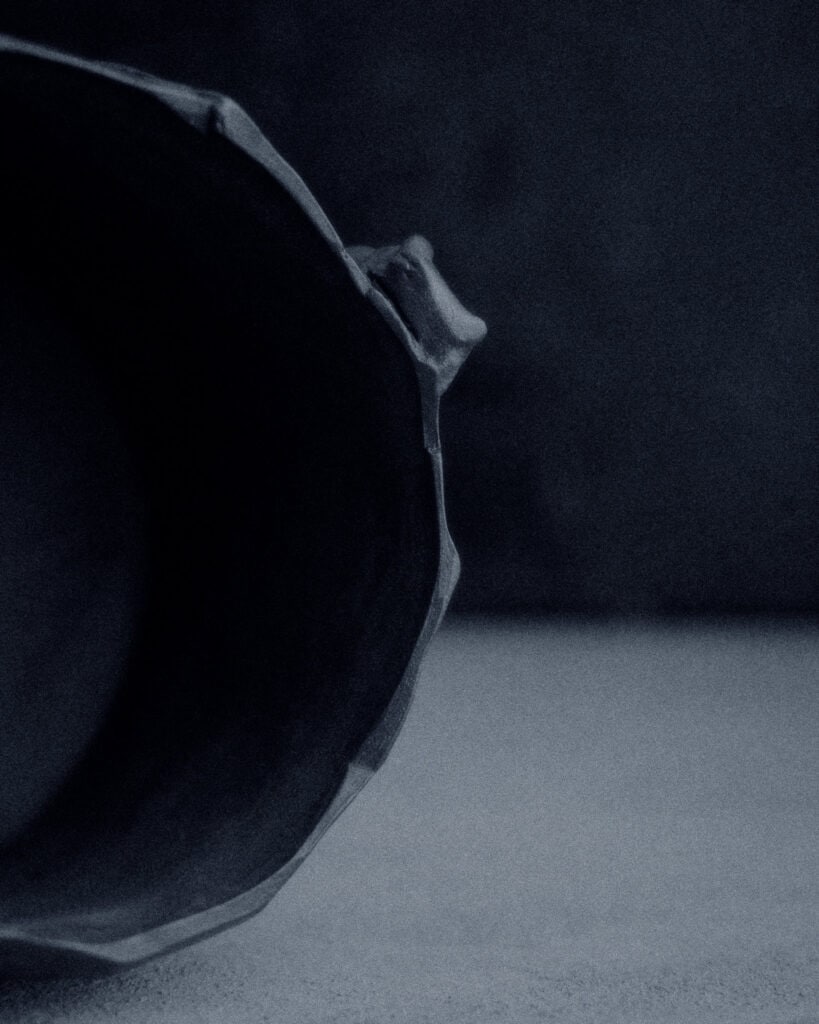 Looking into the interior of a large kurinuki stoneware vessel — hand-carved octagonal opening, dark clay